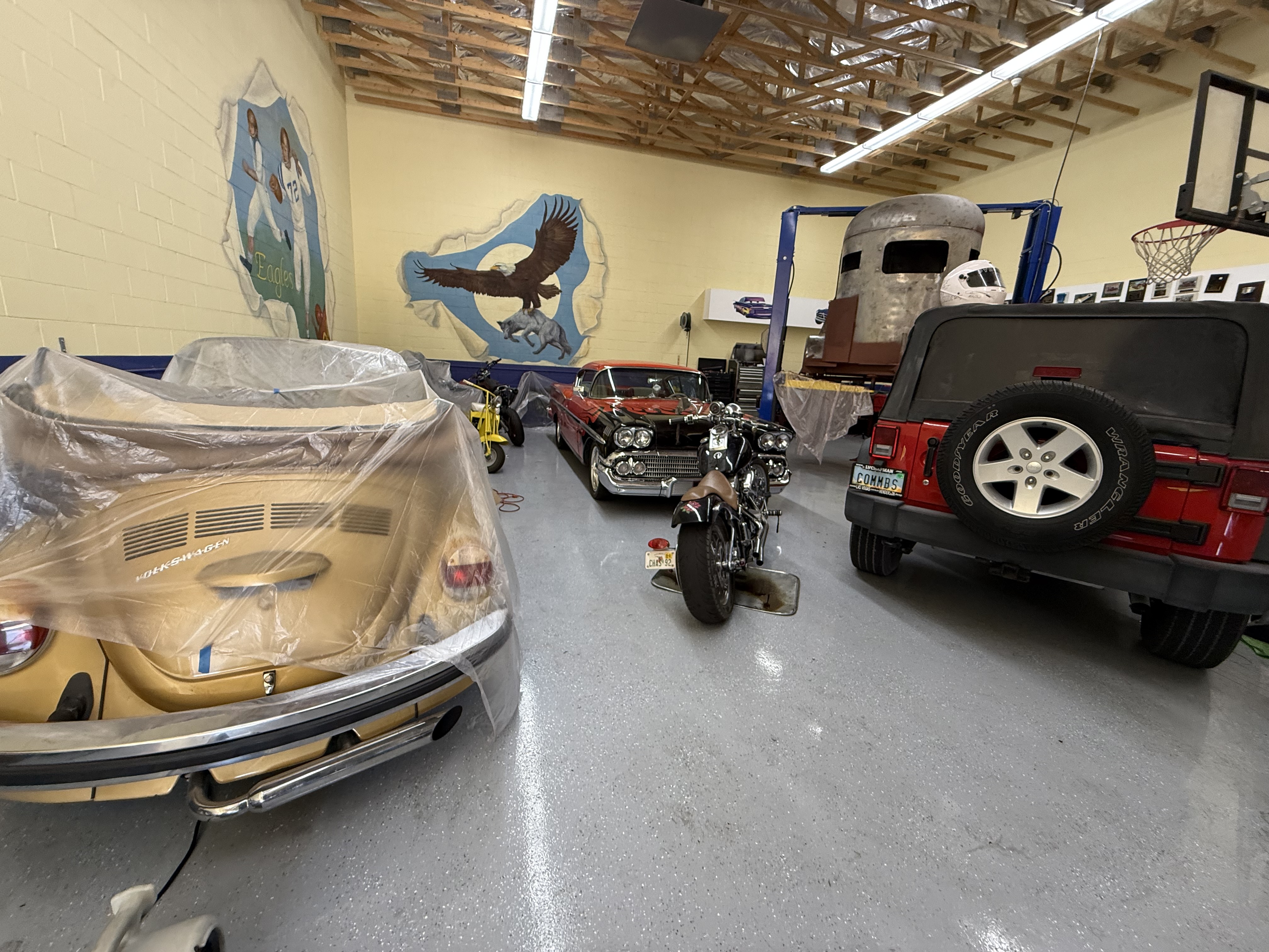 Inside the shop with multiple classic cars and motorcycles